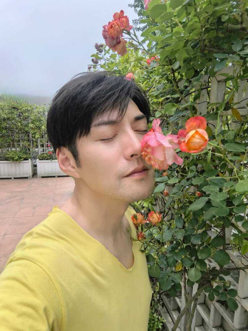 A person smelling a flower

Description automatically generated